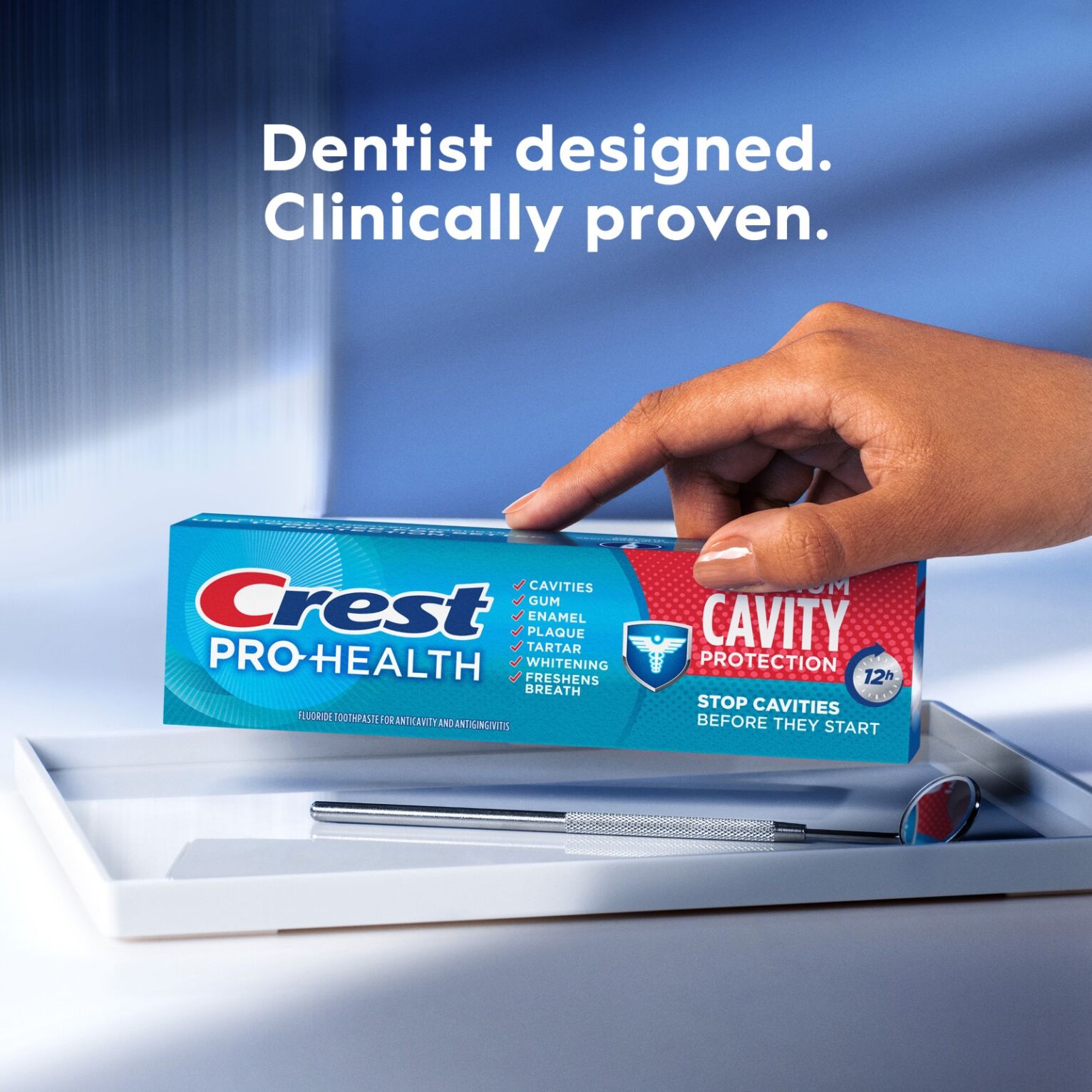 female hand placing a box of Crest Pro-Health Maximum Cavity Protection on dental tray