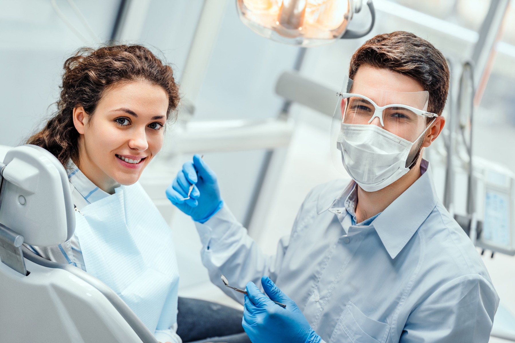 Dental Professional showing a male patient how to use electric toothbrush.